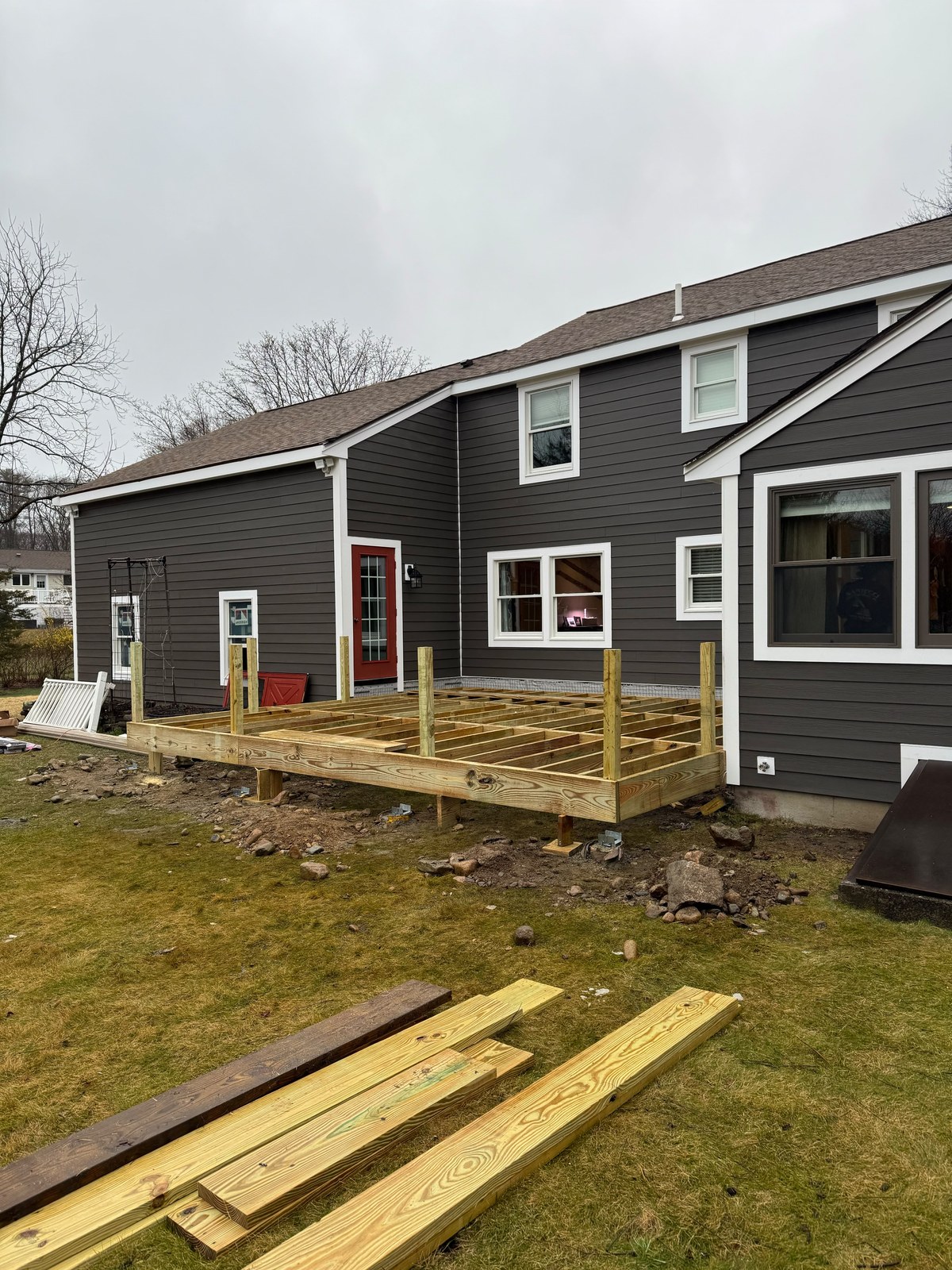 Deck framing under construction in Framingham MA: pressure-treated joists and posts